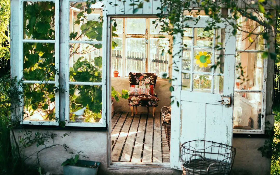 Greenhouse with colorful folding chair Love my work? buy me a coffee ☕ PayPal - a.smit@mac.com by Community Gardening opened door of house